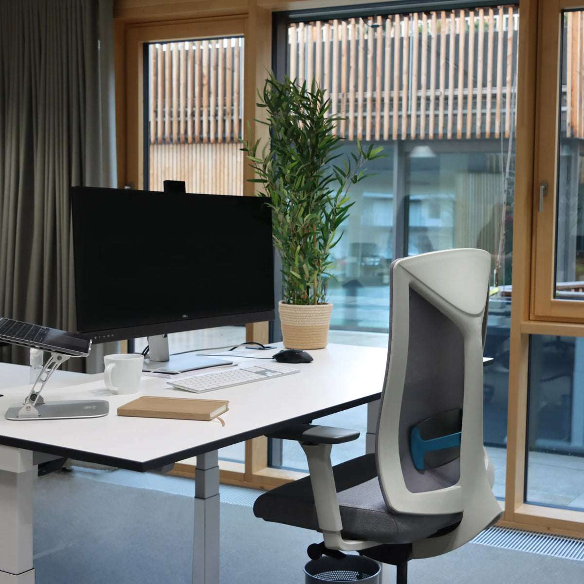 Grauer Counterstuhl HALIFAX WORK an einem weißen Schreibtisch in einem hellen Raum von hjh OFFICE